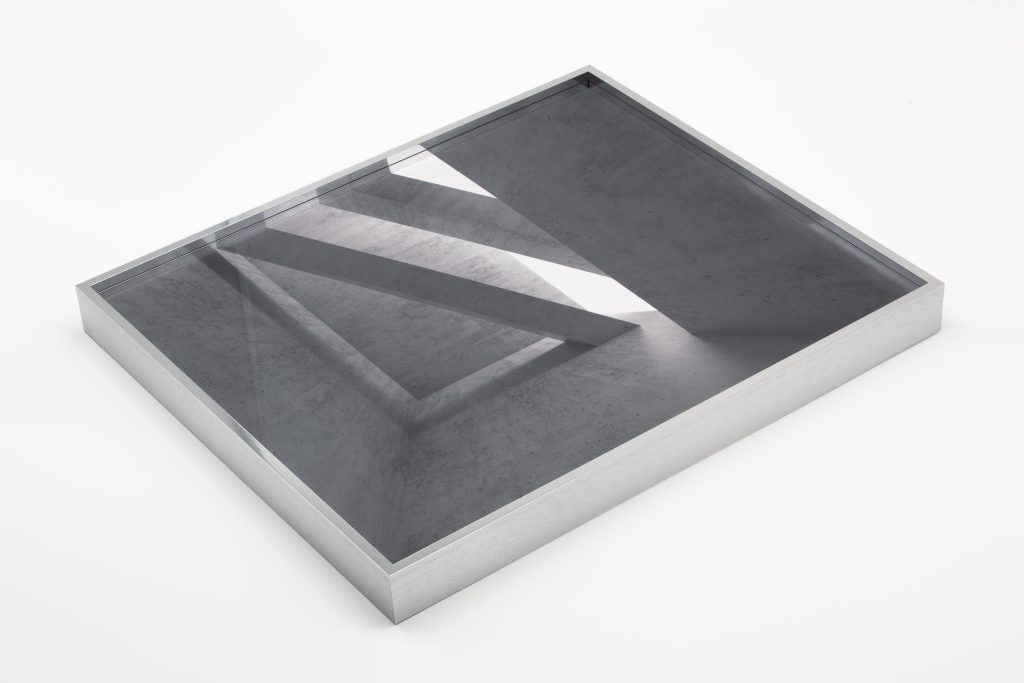 Minimalistischer Bilderrahmen aus Aluminium mit moderner Architekturaufnahme hinter Glas